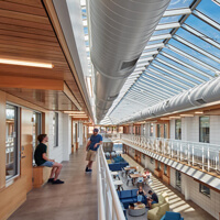 Students talk together on the first and second floor of the sunny atrium